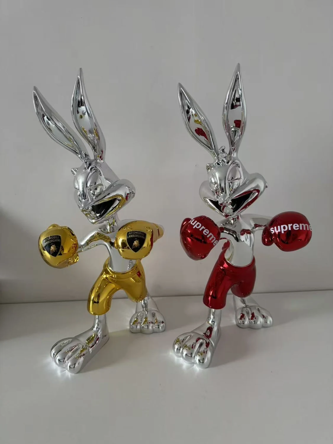 Pair of metallic character display sculptures